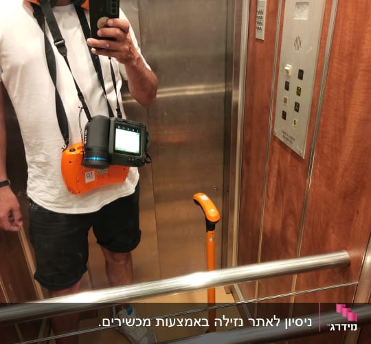 אדם במעלית עם ציוד לאיתור נזילות
